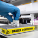 A lab technician extracting viruses from swab samples in the coronavirus testing laboratory at the Glasgow Royal Infirmary in Scotland, taken February 19, 2020.